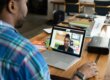 Eine Person sitzt vor dem Laptop, sie ist unscharf zu sehen und die Perspektive über die Schulter lenkt den Blick auf den Laptop, auf dem eine Person im Videocall zu sehen ist. Beide sind Schwarz und tauschen sich wahrscheinlich über Mikroaggressionen weißer Menschen aus.